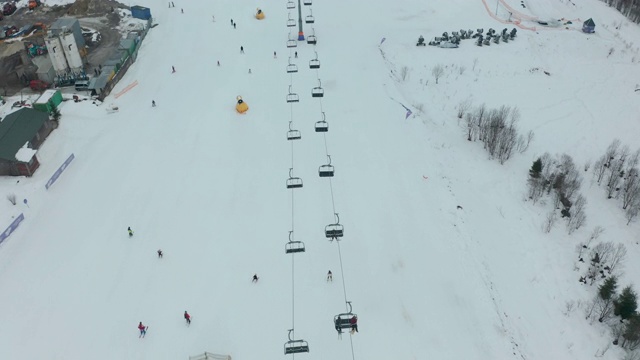 鸟瞰图:滑雪场、斜坡、缆车。索道把滑雪者吊到山上。冬季活动。视频素材