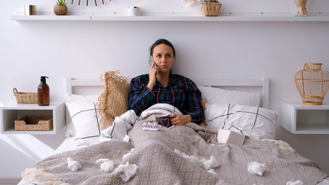 生病的女人在家里的床上打电话视频素材