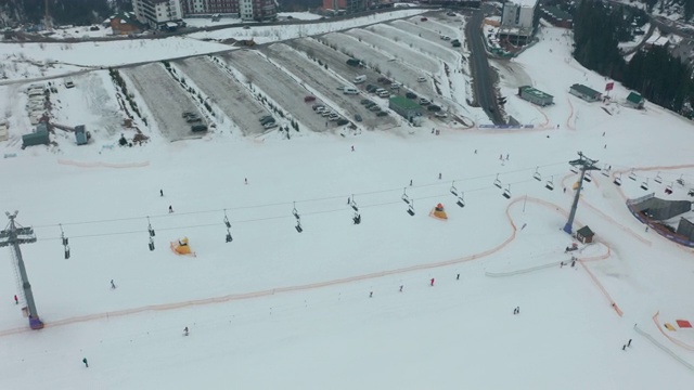 鸟瞰图:滑雪场、斜坡、缆车。索道把滑雪者吊到山上。冬季活动。视频素材