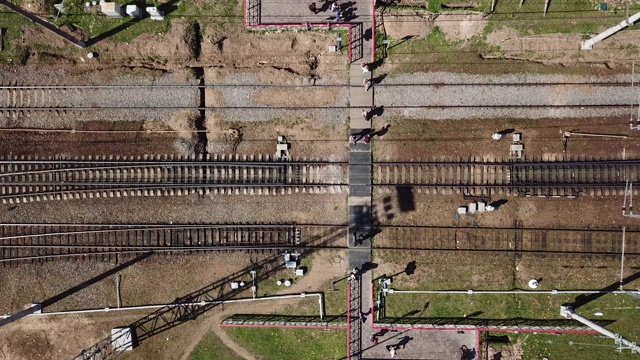 鸟瞰图的一个危险的铁路Crossing在城市。人们在铁轨上行走视频素材