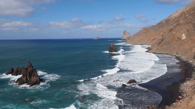 巨大的海浪冲击着特内里费岛海岸，这里有美丽的山地景观。视频素材