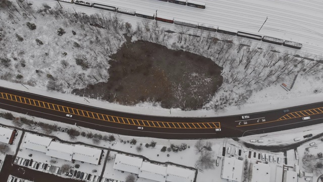 鸟瞰城镇的屋顶、睡眠区和积雪覆盖的道路全景视频素材