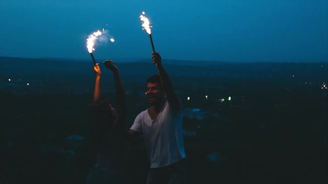 这个男人和女人在户外用火把玩得很开心。慢动作视频素材