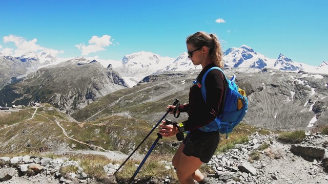 腰上女子徒步下山，同时看瑞士阿尔卑斯山的景色视频素材