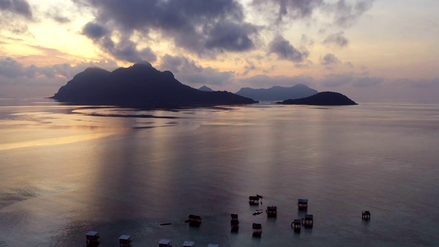 鸟瞰地平线上的日出与游牧海吉普赛水村位于西巴丹麦加岛，仙本那，马来西亚，婆罗洲。视频素材