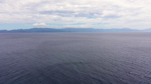 海景与大岛在远处。蓝色的大海和天空与云，从无人机观看视频素材