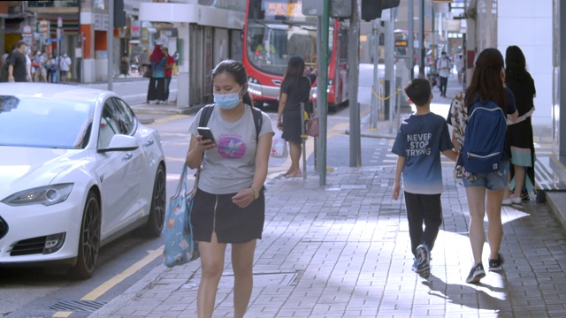 2020年6月，中国香港上环，行人过马路时戴口罩视频下载