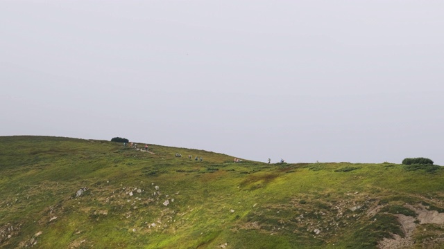 一群背着徒步背包的游客攀登山脉。远处的观点视频素材