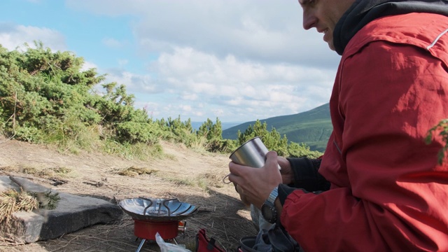 游客在山里，在煤气炉上泡茶。单独旅行视频素材