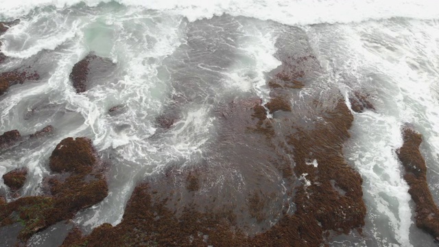 岩石海滩海浪无人机白色泡沫水飞溅击中岩石悬崖视频素材