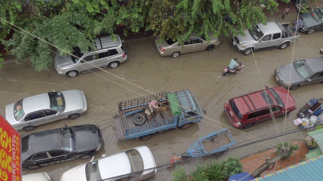 头顶上的车辆和摩托车通过一个小洪水街道视频素材