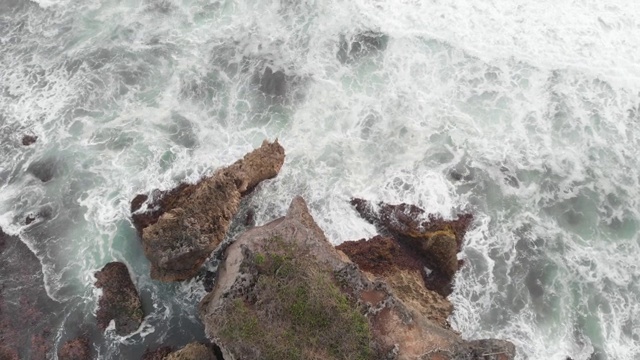 岩石海滩海浪无人机白色泡泡泡沫水飞溅击中悬崖岩石视频素材