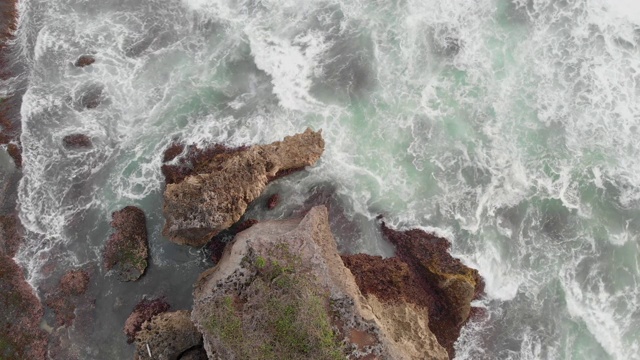 岩石海滩海浪无人机白色泡沫水溅击中悬崖岩石视频素材