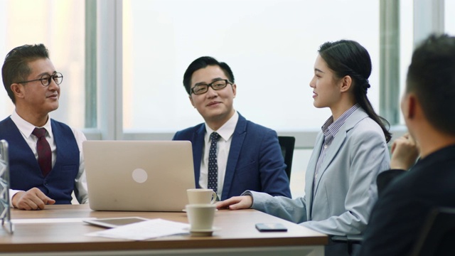 年轻的亚洲女商人和商人在团队会议上握手视频素材