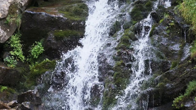 野生山瀑布。快速下落的水撞击石头。慢镜头240视频素材