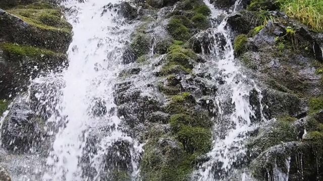 野生山瀑布。快速下落的水击中石头。慢动作视频素材