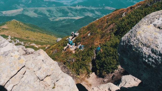 一群背着背包的游客和孩子们沿着山上的石头小径下山视频素材