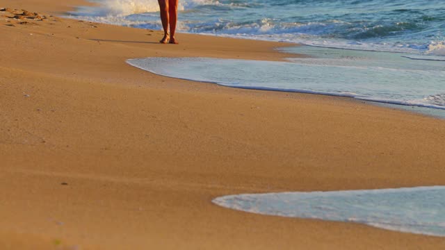 海洋海滩日出。清晨在沙滩上散步放松的女人视频素材