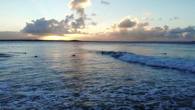 在澳大利亚阳光海岸的努萨头冲浪时间流逝。海浪沿着海岸翻滚，冲浪者享受着深蓝色的海水视频素材