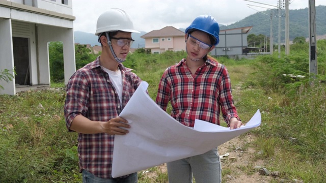 年轻的亚洲夫妇工头工程家庭检查建筑房子回家检查与看，并指出施工检查建筑家在工作现场给客户以新的常态视频素材