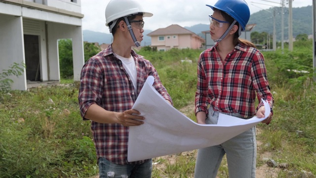 年轻的亚洲夫妇工头工程家庭检查建筑房子回家检查与看，并指出施工检查建筑家在工作现场给客户以新的常态视频素材