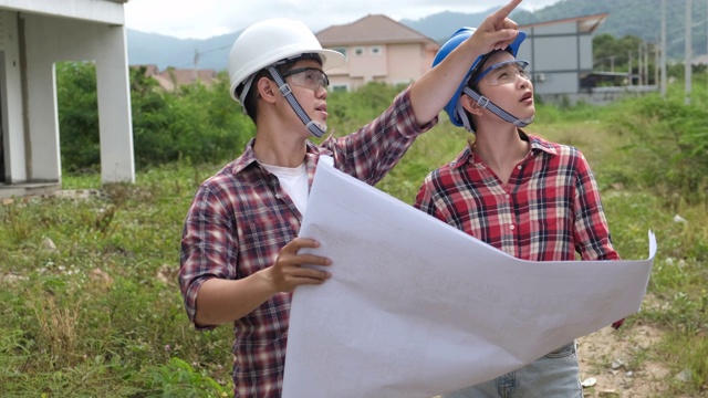 年轻的亚洲夫妇工头工程家庭检查建筑房子回家检查与看，并指出施工检查建筑家在工作现场给客户以新的常态视频素材