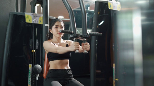 年轻的健身女士在健身房用健身器材进行锻炼视频素材