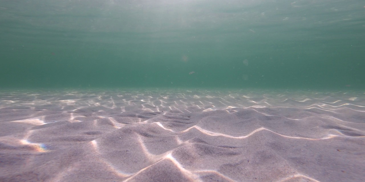 由于阳光和海浪，波罗的海的沙海床上的建筑物视频素材