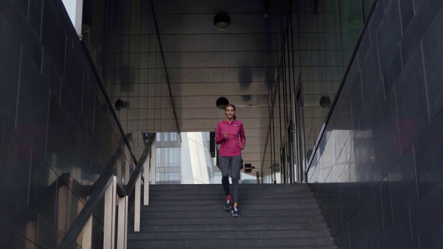 决心适合年轻女子在运动服跑步下的步骤在城市街道在日常慢跑锻炼视频素材