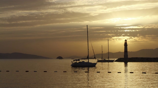 在夕阳海景。海岸上的灯塔。海边小镇Turgutreis和壮观的日落视频素材