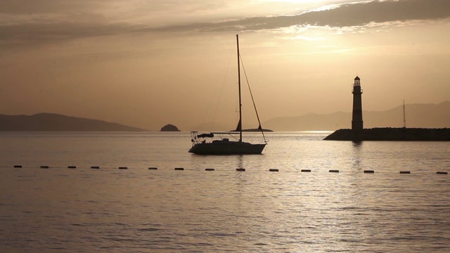 在夕阳海景。海岸上的灯塔。海边小镇Turgutreis和壮观的日落视频素材