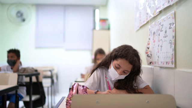 女学生戴着口罩在教室学习视频素材