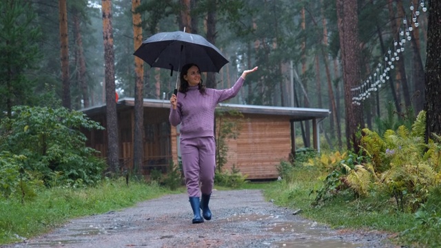 享受雨中漫步的微笑女人视频素材