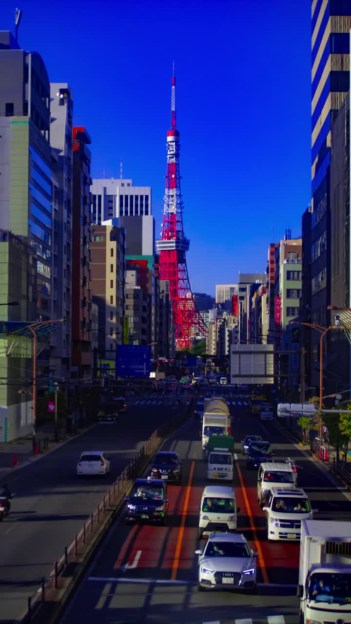 一段时间的交通在东京塔后面的城市街道垂直拍摄视频素材