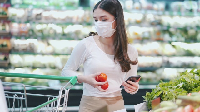 戴口罩的女人在超市选购蔬菜视频素材