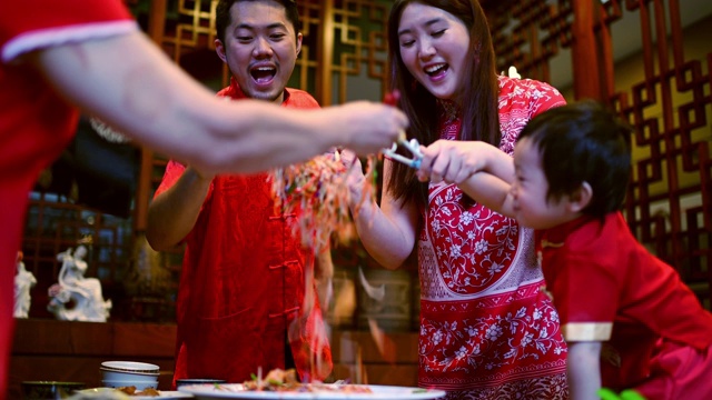 亚洲华人家庭春节团圆饭吃传统菜肴生鱼刘生视频素材