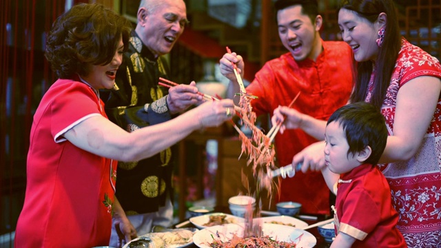 亚洲华人家庭春节团圆饭吃传统菜肴生鱼刘生视频素材