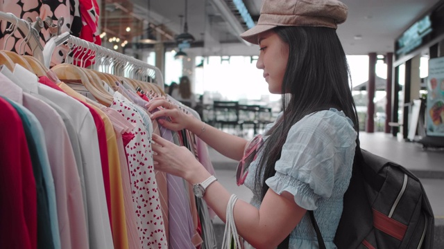 年轻的亚洲女人购物衣服视频素材