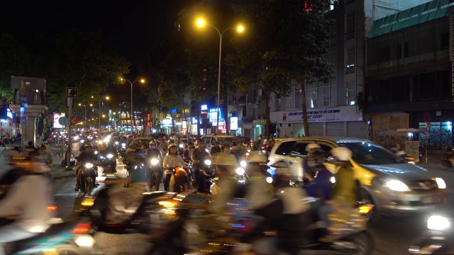 胡志明市，摩托车，汽车，摩托车，十字路口，道路交通，夜晚。视频素材