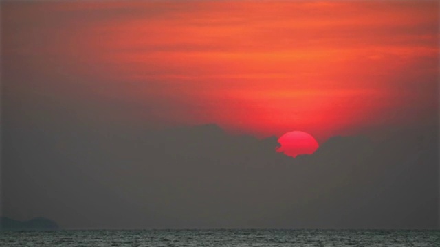 夕阳红天空背后，黑云飘过海面，渔船经过时间流逝视频素材