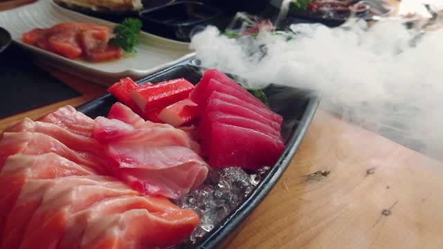 新鲜鲑鱼，金枪鱼和油甘鱼冰碟。日本料理生鱼片套装。平移。视频素材