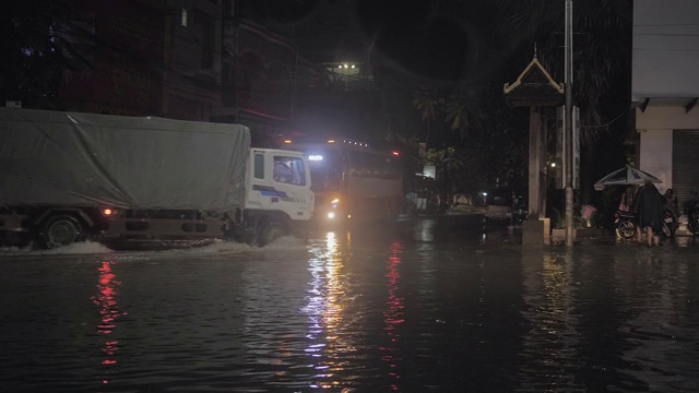 下雨的夜晚，车辆在被水浸透的街道上行驶视频素材