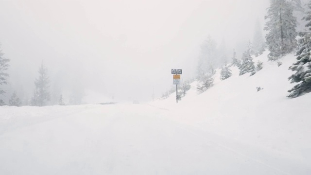 汽车在积雪覆盖的山路上行驶视频素材