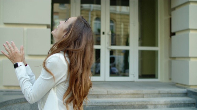 兴奋的女人在城市街道享受成功。关注女商人视频素材