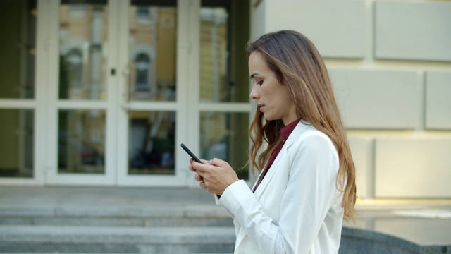 想着女商人在户外用手机发短信视频素材