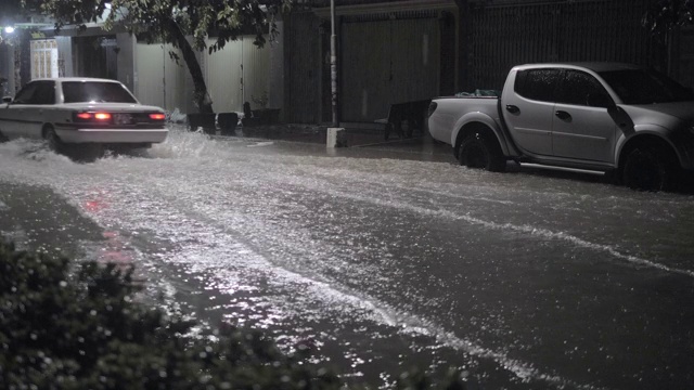 一辆汽车在雨中穿过被水浸透的街道视频素材