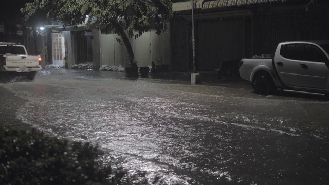 一辆汽车在雨中穿过被水浸透的街道视频素材