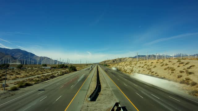 在加州棕榈泉的I-10高速公路上，风力涡轮机和交通的延时视频素材