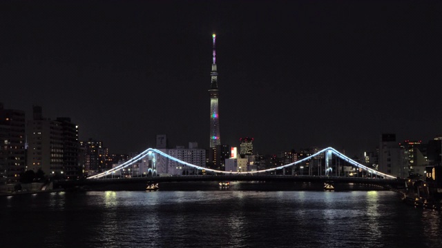 夜晚，东京天空树在住田河清津桥上空翱翔视频素材