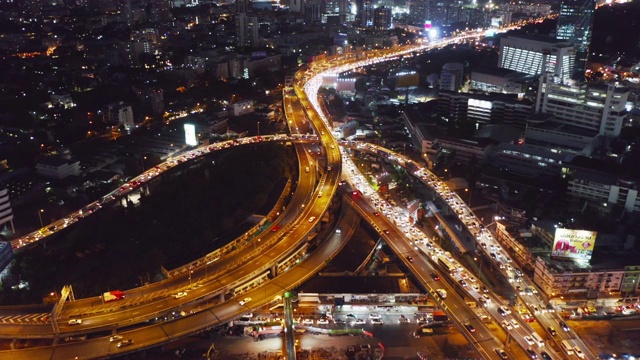 在高速公路路口行驶的汽车鸟瞰图。桥梁、街道、道路在建筑网络中的连接概念。前视图。曼谷夜市，泰国。视频素材